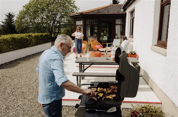 A family enjoying a BBQ on the decking